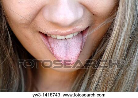 Stock Image - Portrait of a young woman with her tongue out. Fotosearch