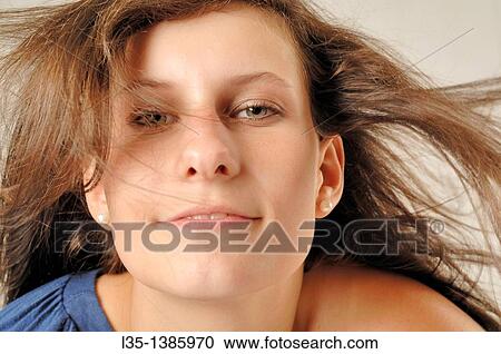 Stock Image - Portrait of a young woman with wind in her hair. Fotosearch