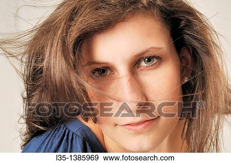 Stock Photo - Portrait of a young woman with wind in her hair. Fotosearch
