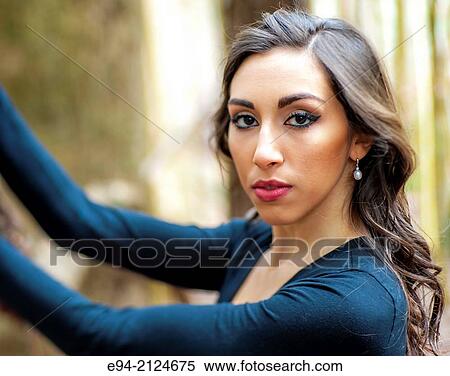 Portrait of a19 year old brunette woman looking directly at the camera wearing a black top surrounded by bamboo. View Large Photo Image Stock Photography - Portrait of a19 year old brunette woman looking directly at the camera wearing a black top surrounded by bamboo.. Fotosearch