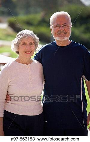 Stock Image - Portrait of active senior couple in exercise clothes embracing each other in an outdoor park.. Fotosearch