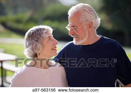 Portrait of active senior couple looking lovingly at each other in an outdoor park. View Large Photo Image Stock Photograph - Portrait of active senior couple looking lovingly at each other in an outdoor park.. Fotosearch