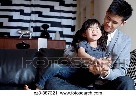 Stock Image - Portrait of an Asian father and daughter.. Fotosearch