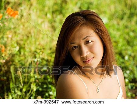 Portrait of an Asian young woman in a field or garden View Large Photo Image Stock Photo - Portrait of an Asian young woman in a field or garden. Fotosearch