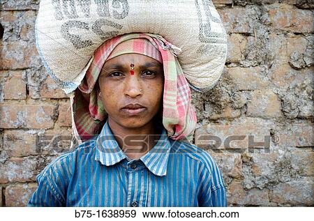 Portrait of an Indian race woman with a bundle on his head loaded in Mundgod, Karnataka, India, Asia View Large Photo Image Stock Photo - Portrait of an Indian race woman with a bundle on his head loaded in Mundgod, Karnataka, India, Asia. Fotosearch