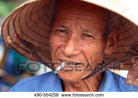 Portrait of an old, friendly vietnamese man smoking a cigarette, Hoi An, Vietnam, Southeast Asia View Large Photo Image Stock Photo - Portrait of an old, friendly vietnamese man smoking a cigarette, Hoi An, Vietnam, Southeast Asia. Fotosearch
