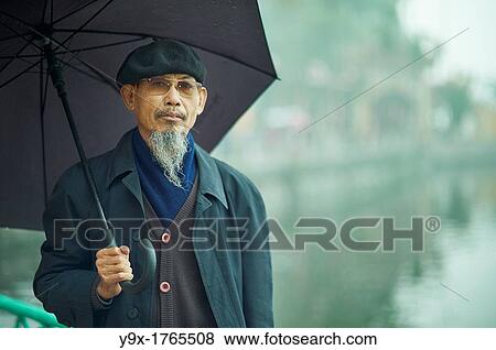 Stock Photo - Portrait of an old man with a long beard wearing sunglasses and a beret. Fotosearch