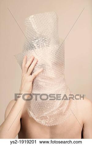 Portrait of anxious young adult male wrapped in transparent plastic He is looking sad, shy and discontent View Large Photo Image Stock Image - Portrait of anxious young adult male wrapped in transparent plastic He is looking sad, shy and discontent. Fotosearch