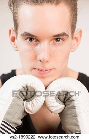 Portrait of athletic young man wearing boxercise gloves Looking at camera with confident expression View Large Photo Image Stock Image - Portrait of athletic young man wearing boxercise gloves Looking at camera with confident expression. Fotosearch