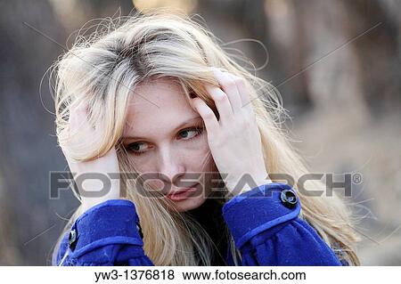 Stock Photo - Portrait of beautiful woman in autumn outdoors in blue coat. Fotosearch