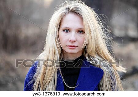 Stock Photo - Portrait of beautiful woman in autumn in blue coat. Fotosearch