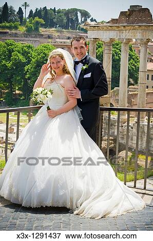 Stock Photo - Portrait of bride and groom in front of Fori Imperiali in Rome, Italy. Fotosearch