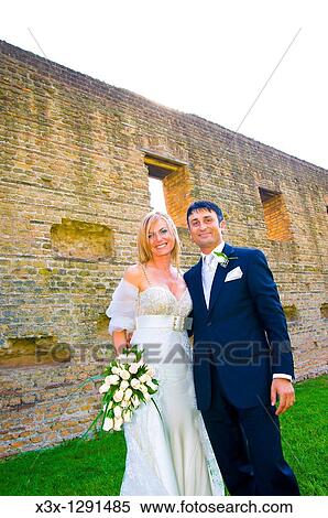 Stock Photography - Portrait of bride and groom in front of an ancient wall in Rome Italy. Fotosearch