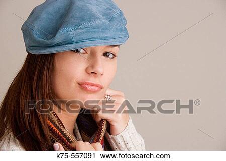Stock Image - Portrait of caucasian-hispanic woman in her twenties with blue suede cap and scarf.. Fotosearch