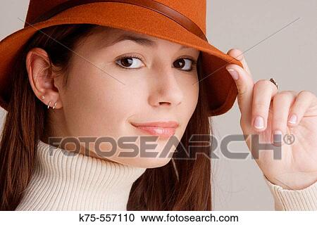 Stock Image - Portrait of caucasian-hispanic woman in her twenties with a hat and a turtleneck.. Fotosearch