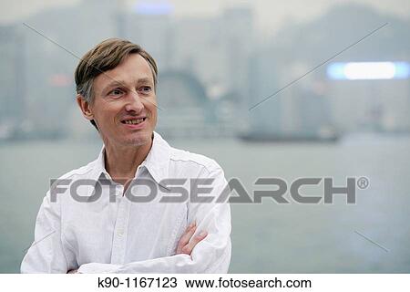 Portrait of caucasian man, looking away, with the silhouette of the buildings of Hong Kong Island in the background, Hong Kong, China, Far East Asia View Large Photo Image Stock Image - Portrait of caucasian man, looking away, with the silhouette of the buildings of Hong Kong Island in the background, Hong Kong, China, Far East Asia. Fotosearch