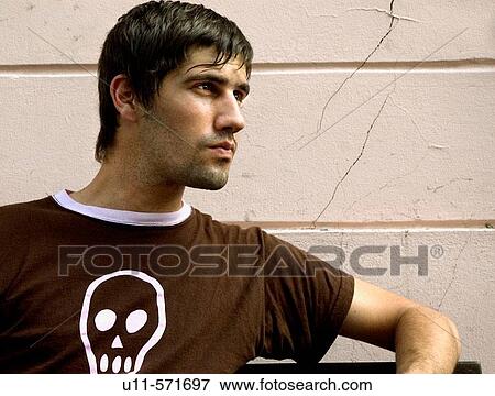 Stock Photo - Portrait of caucasian man sitting on bench.. Fotosearch
