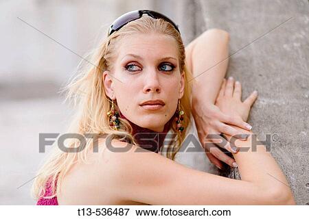Stock Photo - Portrait of classy young blonde woman waiting for someone outside. Fotosearch