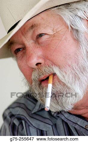 Portrait of cowboy smoking cigarette View Large Photo Image Stock Photo - Portrait of cowboy smoking cigarette. Fotosearch
