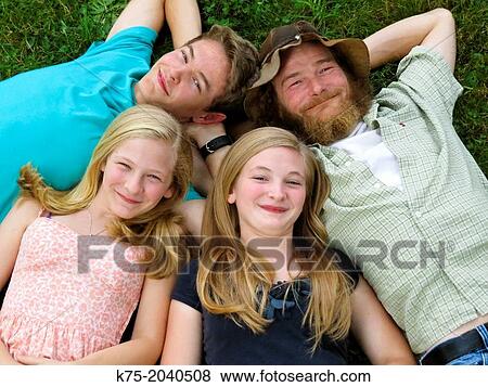 Portrait of family lying down on lawn looking up View Large Photo Image Stock Photo - Portrait of family lying down on lawn looking up. Fotosearch