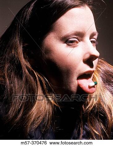 Portrait of female in her 20s with a pill capsule on her tongue View Large Photo Image Stock Photograph - Portrait of female in her 20s with a pill capsule on her tongue. Fotosearch