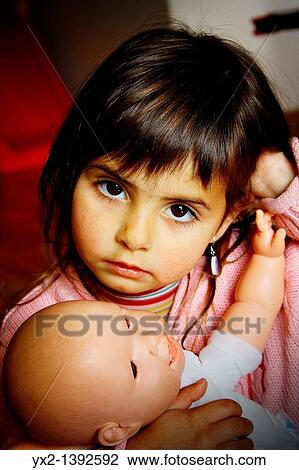 Stock Image - Portrait of girl with doll. Fotosearch