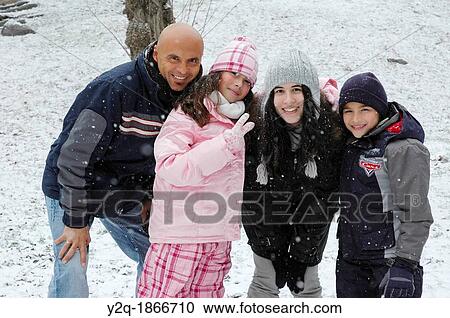 Portrait of happy Caucasian family of four posing in snow smiling View Large Photo Image Stock Image - Portrait of happy Caucasian family of four posing in snow smiling. Fotosearch
