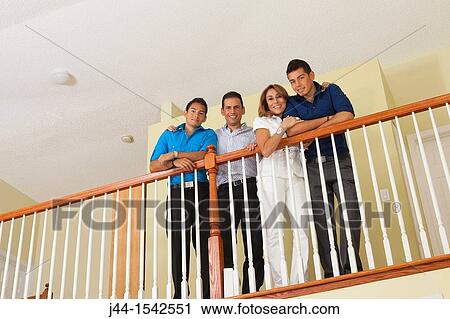 Portrait of Hispanic family standing by railing in house View Large Photo Image Stock Image - Portrait of Hispanic family standing by railing in house. Fotosearch