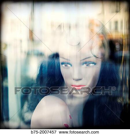 Stock Photo - Portrait of mannequin in a shop window with reflections on the glass in Paris, France. Fotosearch