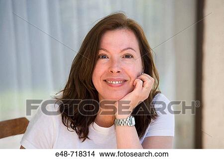 Portrait of middle aged woman sitting outside smiling View Large Photo Image Picture - Portrait of middle aged woman sitting outside smiling. Fotosearch