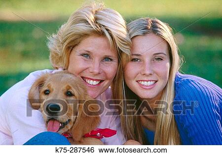 Stock Photograph - Portrait of mom, daughter and their dog. Fotosearch