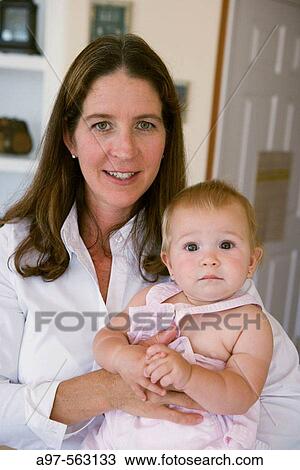 Portrait of mother and blonde infant girl. Mother has smile. Infant has a look of curious interest. View Large Photo Image Stock Image - Portrait of mother and blonde infant girl. Mother has smile. Infant has a look of curious interest.. Fotosearch
