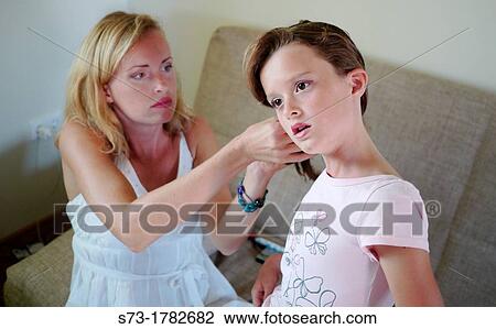 Portrait of mother doing her daughter's hair View Large Photo Image Stock Image - Portrait of mother doing her daughter's hair. Fotosearch