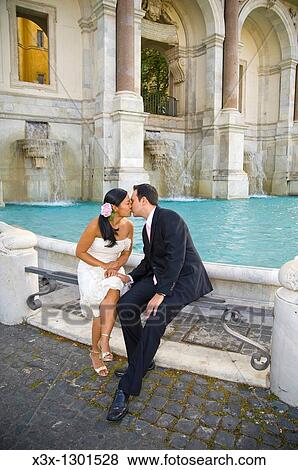 Portrait of newlyweds sitting and kissing in front of Water fountain Fontanone dell Acqua Paola known as Fontanone del Gianicolo Rome Italy View Large Photo Image Stock Photo - Portrait of newlyweds sitting and kissing in front of Water fountain Fontanone dell Acqua Paola known as Fontanone del Gianicolo Rome Italy. Fotosearch