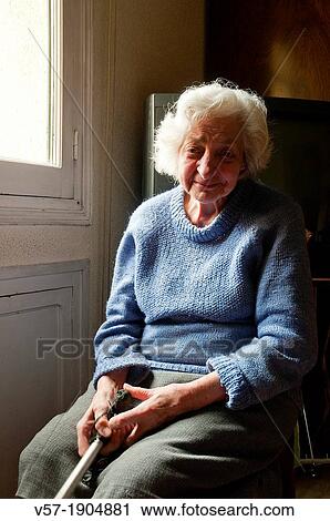 Portrait of old woman at home, sitting by the window, smiling and looking at the camera View Large Photo Image Stock Image - Portrait of old woman at home, sitting by the window, smiling and looking at the camera. Fotosearch