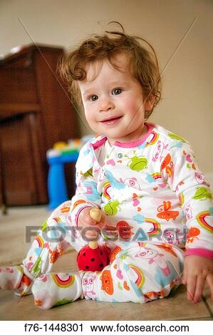 Portrait of one year old girl with red hair sitting on floor holding toy rattle View Large Photo Image Stock Image - Portrait of one year old girl with red hair sitting on floor holding toy rattle. Fotosearch