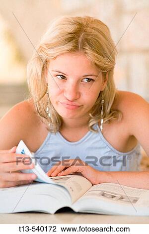 Portrait of pretty schoolgirl unhappy before heavy book View Large Photo Image Stock Image - Portrait of pretty schoolgirl unhappy before heavy book. Fotosearch