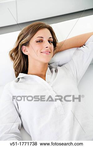 Portrait of relaxed pretty woman on the sofa looking at camera View Large Photo Image Stock Photo - Portrait of relaxed pretty woman on the sofa looking at camera. Fotosearch