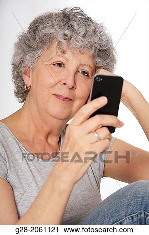 Portrait of Senior woman with grey hair smiling, happy, looking at her telephone in one hand, reading a message View Large Photo Image Stock Image - Portrait of Senior woman with grey hair smiling, happy, looking at her telephone in one hand, reading a message. Fotosearch