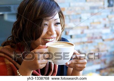 Portrait of smiling beautiful woman drinking cappuccino coffee at a cafe View Large Photo Image Stock Photo - Portrait of smiling beautiful woman drinking cappuccino coffee at a cafe. Fotosearch