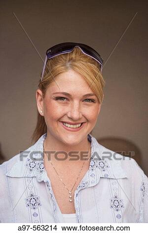 Portrait of smiling young blond woman with sunglasses perched on to of her head. View Large Photo Image Picture - Portrait of smiling young blond woman with sunglasses perched on to of her head.. Fotosearch