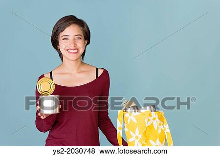 Stock Photo - Portrait of smiling young multiracial woman recycling metal cans. 1015. Fotosearch