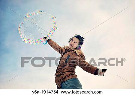 Picture - Portrait of smiling young woman holding umbrella. Fotosearch