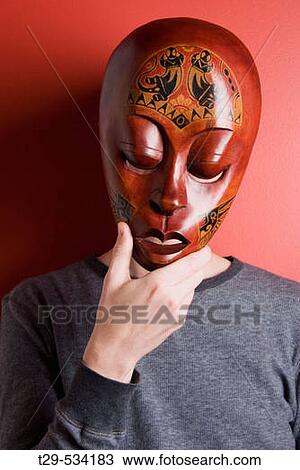 Stock Image - Portrait of someone wearing a red mask. Fotosearch