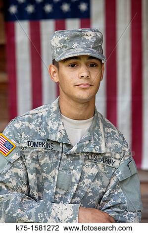 Stock Image - Portrait of teen Army soldier in front of flag. Fotosearch