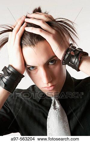 Portrait of teen boy wearing wristbands and a silver tie, pulling his back. View Large Photo Image Picture - Portrait of teen boy wearing wristbands and a silver tie, pulling his back.. Fotosearch
