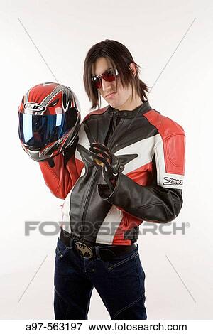 Stock Photo - Portrait of teen boy with motorcycle jacket and helmet, and Elvis sneer on face. White background.. Fotosearch