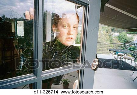 Picture - Portrait of teengirl through window. Fotosearch