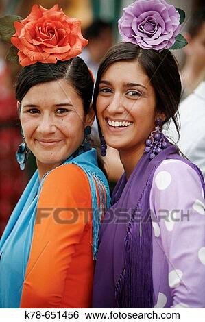 Stock Photograph - Portrait of two women wearing traditional flamenco dress during the April Fair, Seville, Spain.. Fotosearch