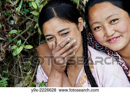 Portrait of two young Tibetan female Labor workers embracing and laughing with each other. View Large Photo Image Stock Photo - Portrait of two young Tibetan female Labor workers embracing and laughing with each other.. Fotosearch